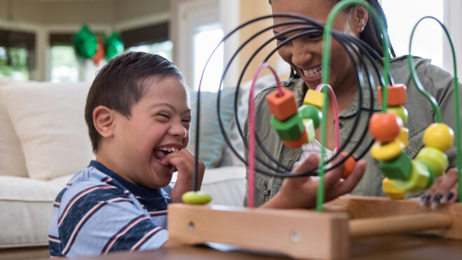 woman playing game with little boy with special needs