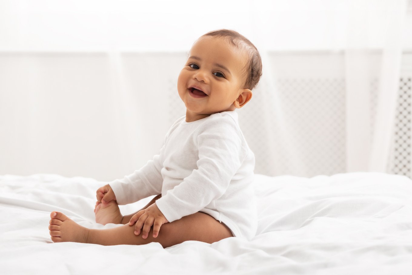 Baby sitting on a bed