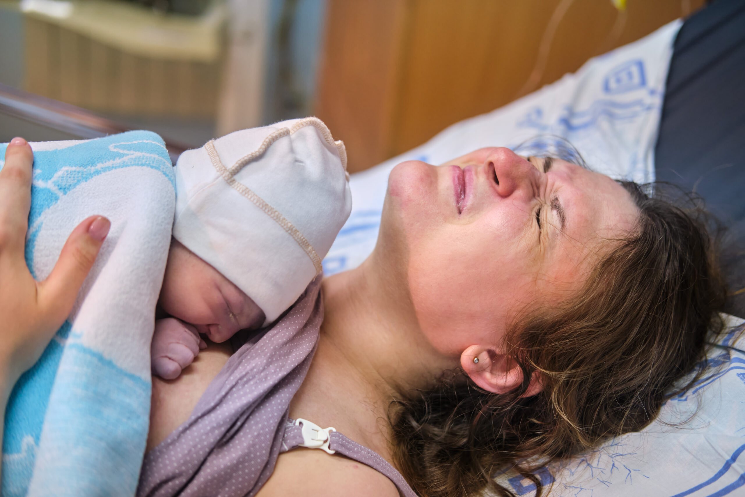 A woman who gave birth to a newborn baby boy. Laying the child out on the mother chest immediately after childbirth, postpartum preeclampsia